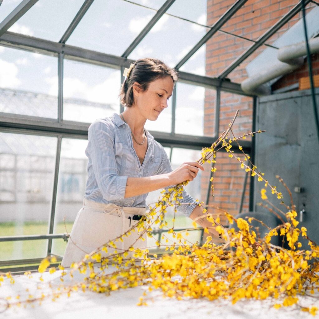 Kayla Powers arranging flowers as part of her Flourish Arts Exhibit