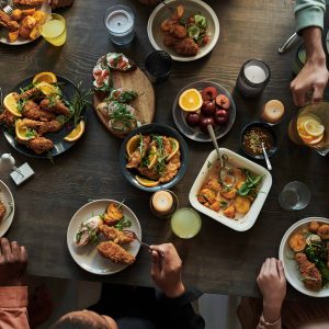 People sitting at dining table High angle view of group of people sitting at dining table and having holiday dinner